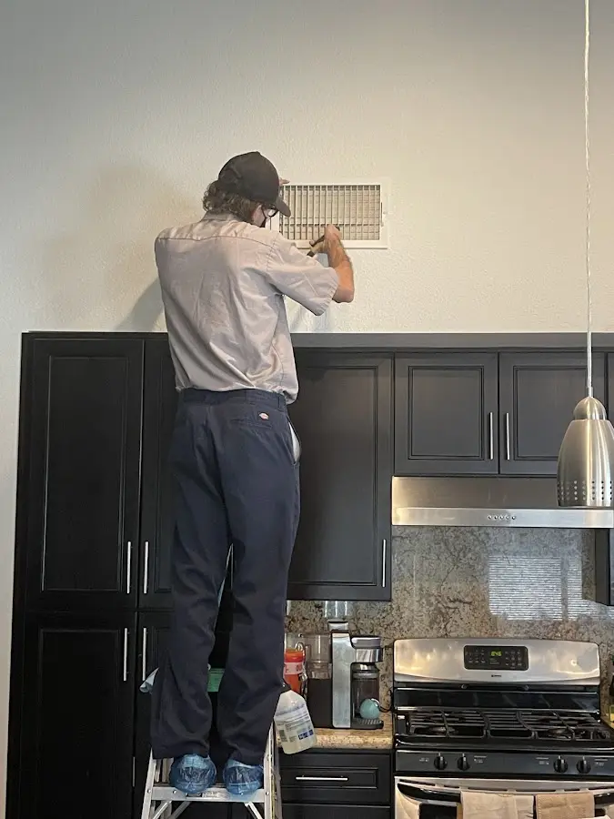 Technician inspecting an air vent during HVAC service in Wheelersburg